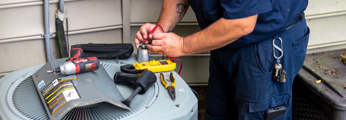 Burch technician working on an outdoor heating/air conditioning unit.