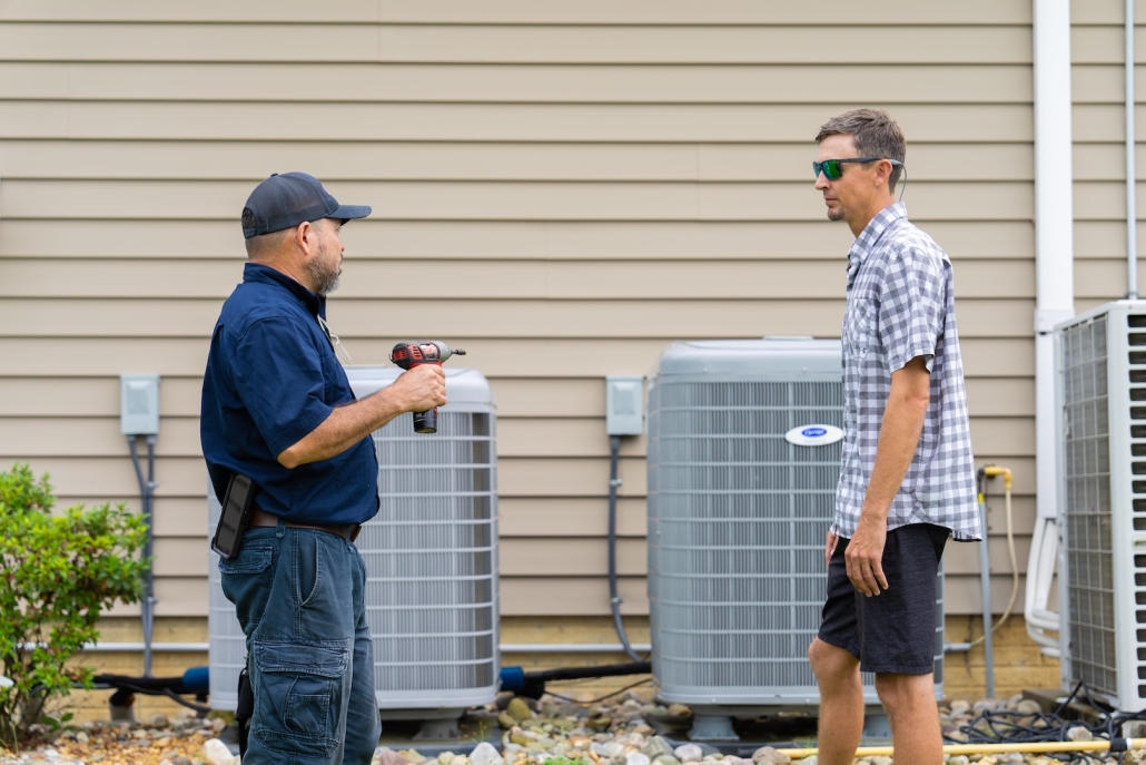Burch_CustomerInteraction-15 Burch technician working with a customer for their heating and cooling unit after doing an AC repair.