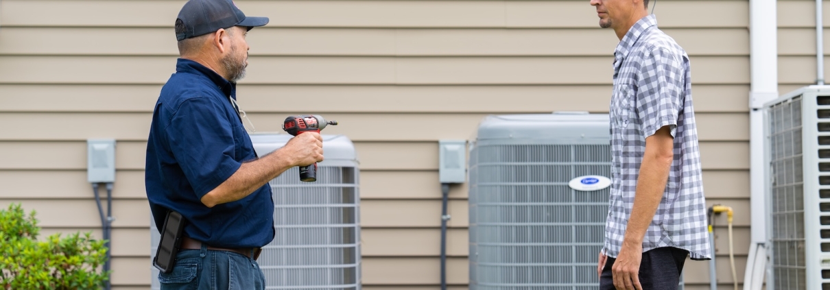 Burch technician working with a customer for their heating and cooling unit after doing an AC repair.