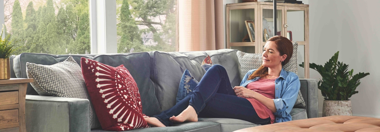 woman on couch relaxing in her warm, cozy home