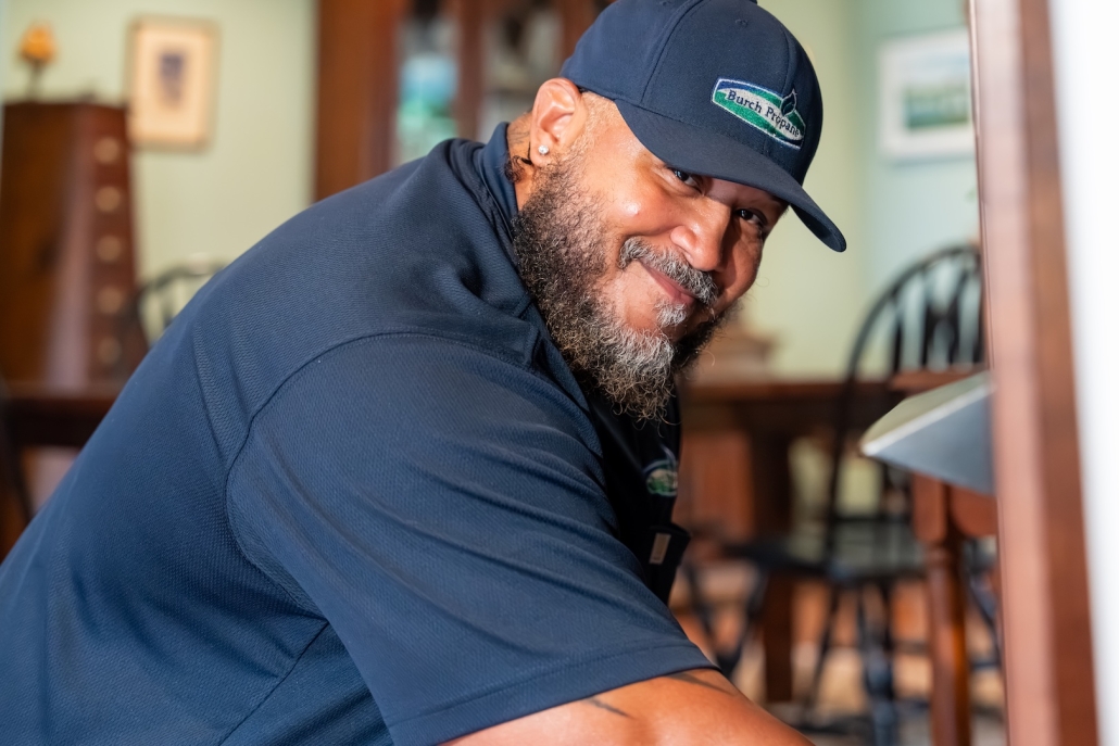 employee working on fireplace and smiling