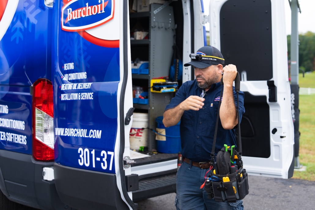 employee walking up to house with tools