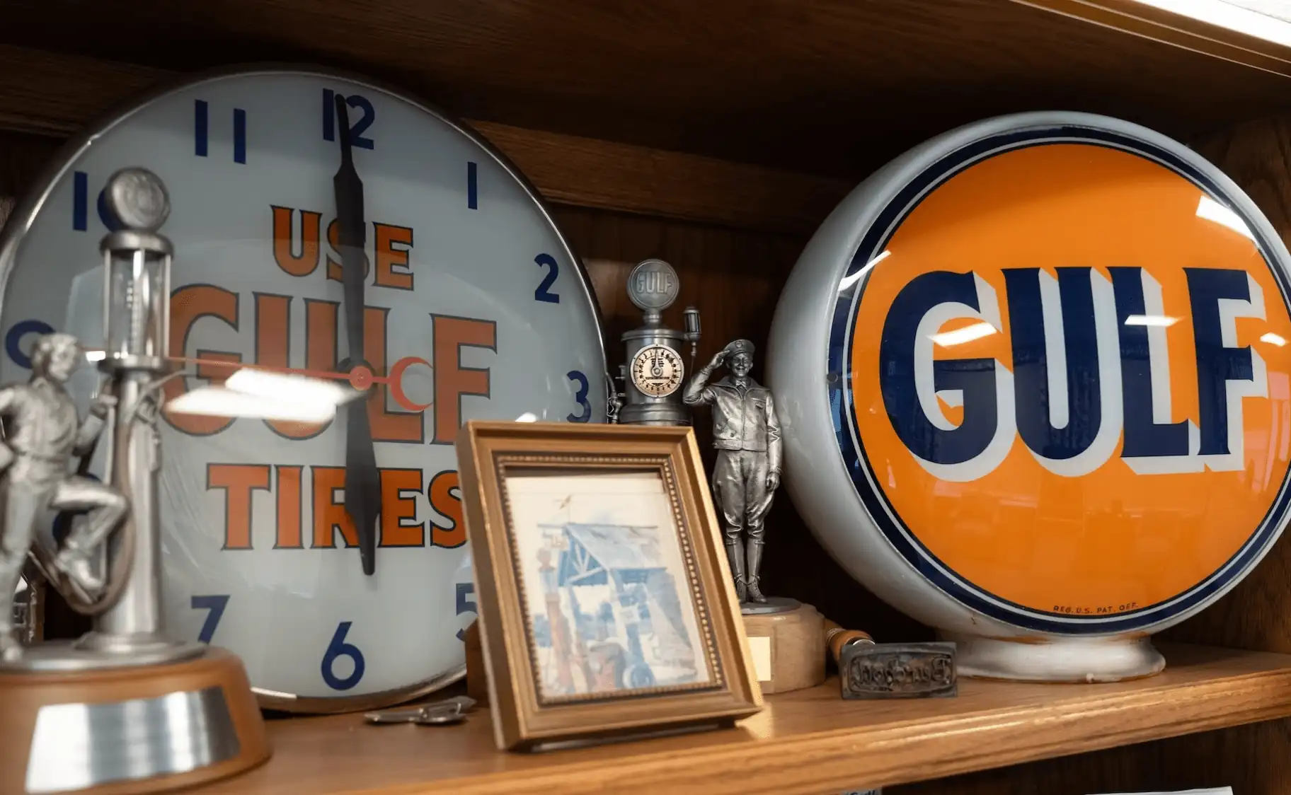 A shelf displaying historical Gulf oil memorabilia alongside awards