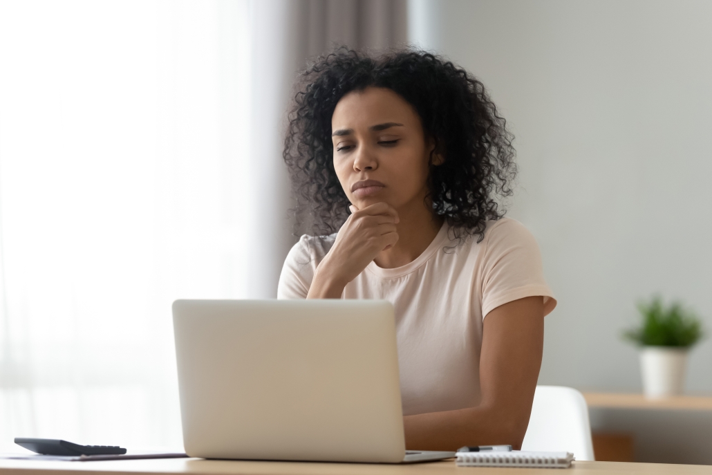 Pensive biracial woman thinking working on laptop lady on computer