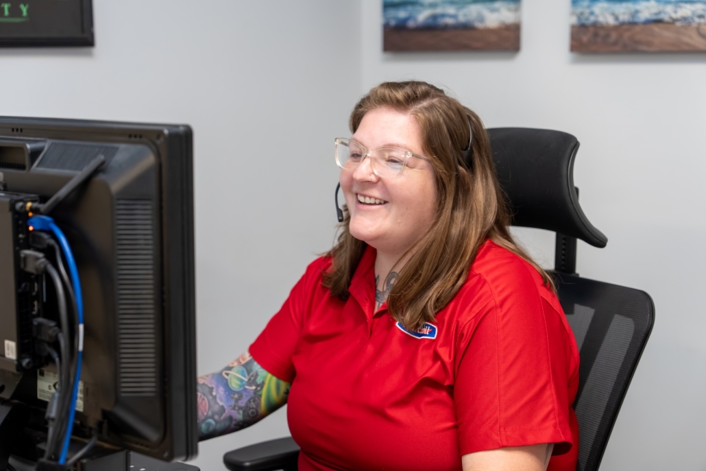Burch Oil & Propane employee smiling on headset in front of computer