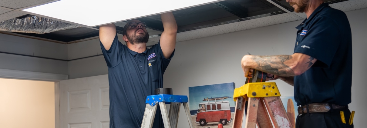 Burch technicians on ladders working on HVAC ducts
