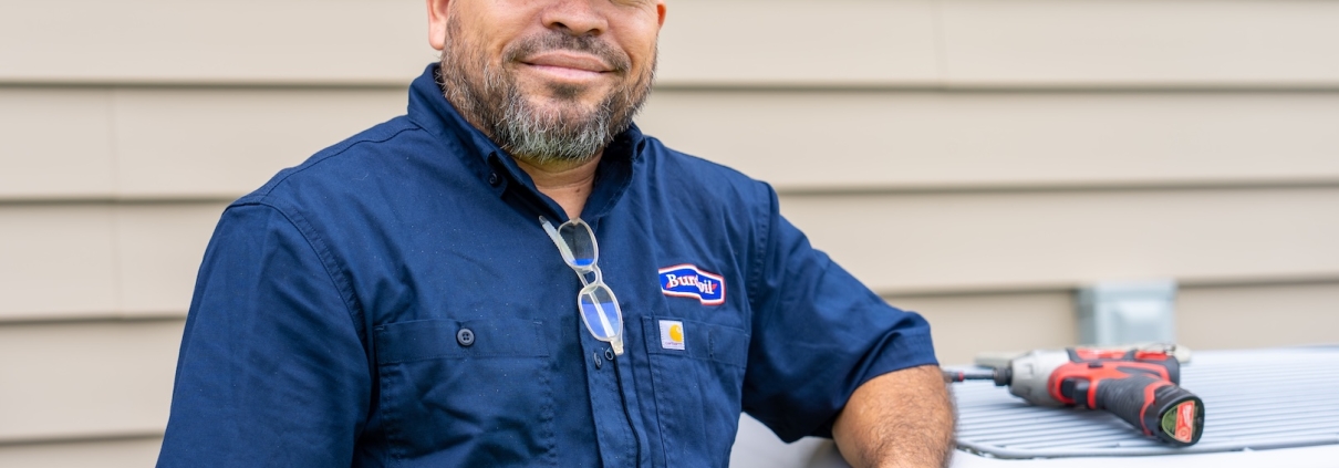 HVAC contractor standing beside an outside air handler